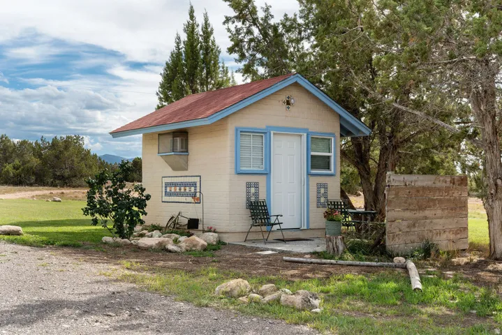 Adobe-style exterior with a red pitched roof, light blue trim, and decorative exterior tiling