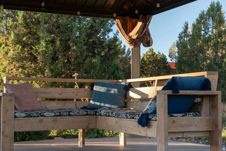 Outdoor wooden L-shaped bench with a solid wood frame