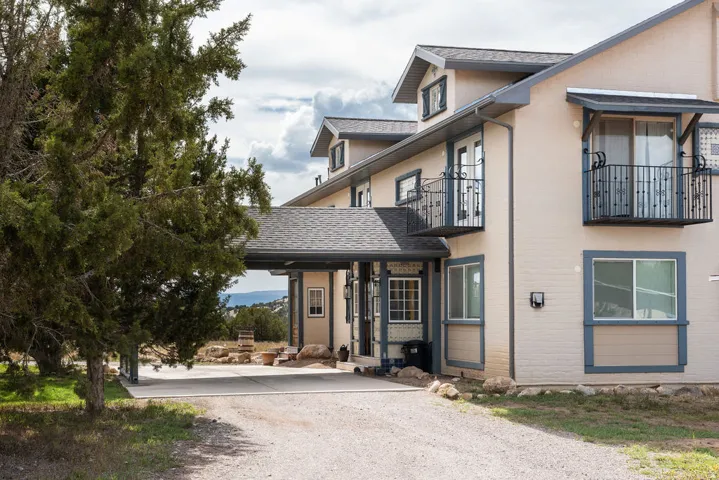 Multi-level exterior with stucco finish, multiple balconies with wrought iron railings, and a covered entryway