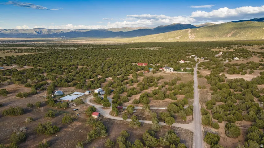 Expansive natural landscape with scattered structures, bordered by distant mountains