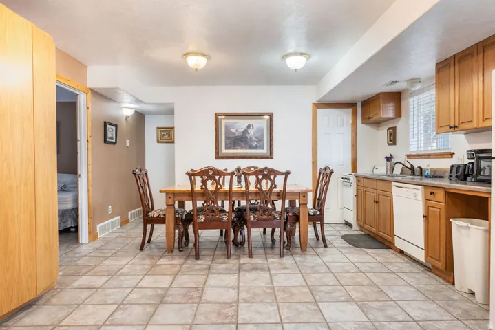 Kitchen and dining area featuring tile flooring, wooden cabinetry, and light-colored countertops