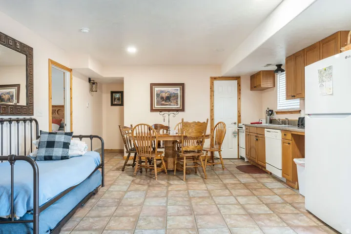 Ceramic tile flooring, built-in kitchen cabinetry, white appliances, recessed lighting, and wall-mounted light fixture