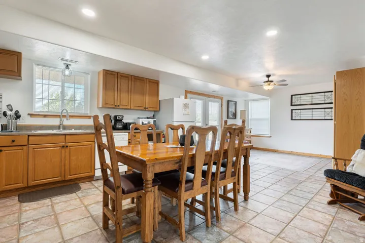 Kitchen and dining area featuring tile flooring, light wood cabinetry, recessed lighting, and a ceiling fan