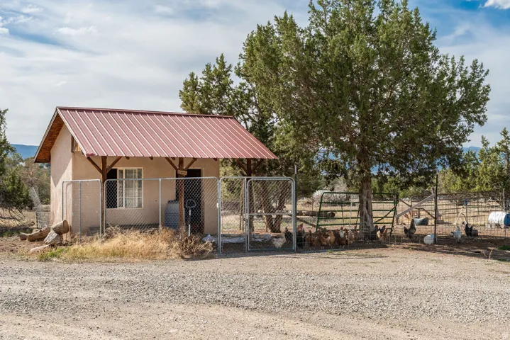 Detached outbuilding with a metal roof and an attached covered porch