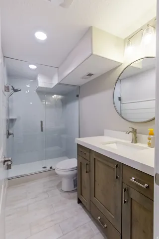 Glass-enclosed shower with white subway tile