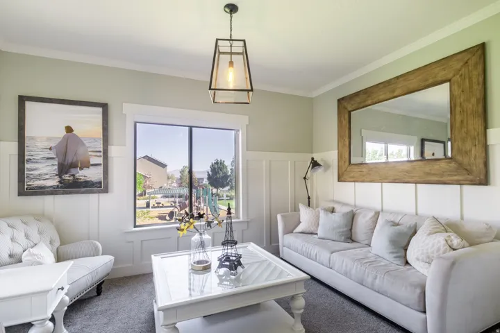 Board and batten wall detailing, crown molding, double-pane window, suspended geometric light fixture, and wood-framed mirror