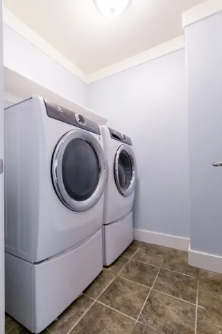 Tiled flooring with white baseboards, light blue walls, and a white ceiling with crown molding