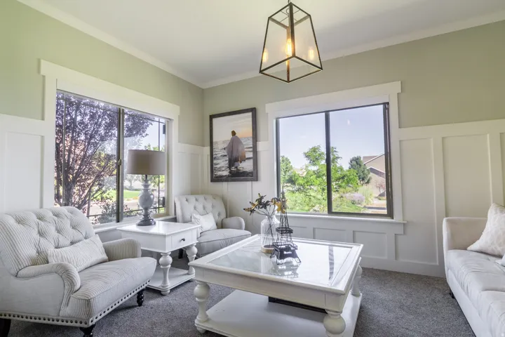 Board and batten wall detailing, crown molding, double windows with white trim, and a contemporary ceiling light fixture