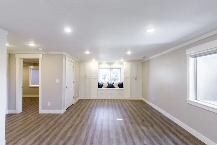 Recessed ceiling lighting, wood-finish flooring, built-in window seating, built-in cabinetry, and white trim