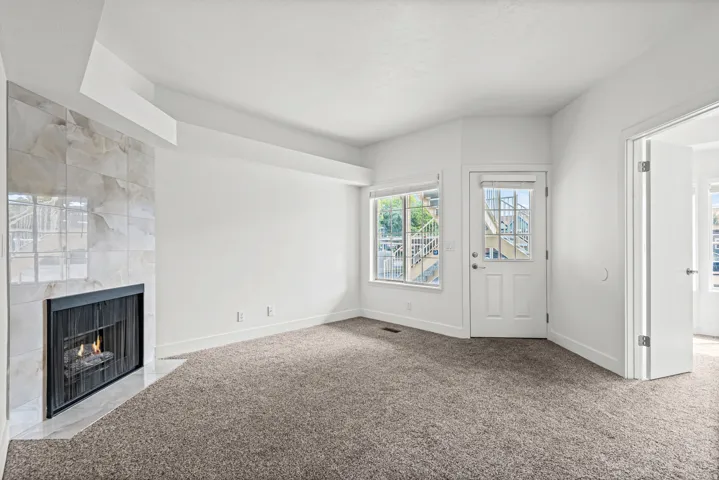 Cozy living area featuring a tiled gas fireplace, recessed ceiling.