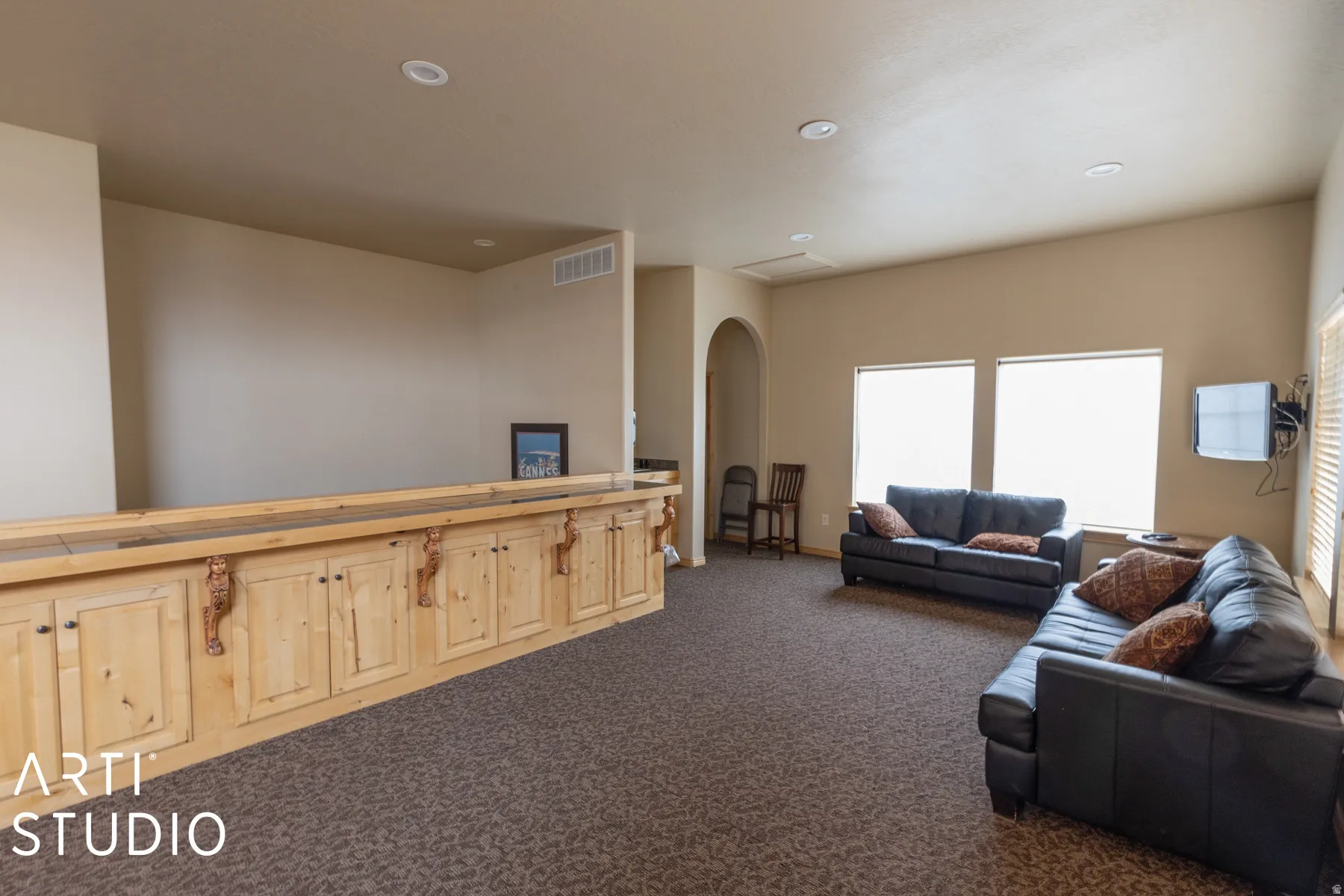 Spacious room featuring a built-in wood bar with cabinet storage, recessed lighting, and vaulted ceilings