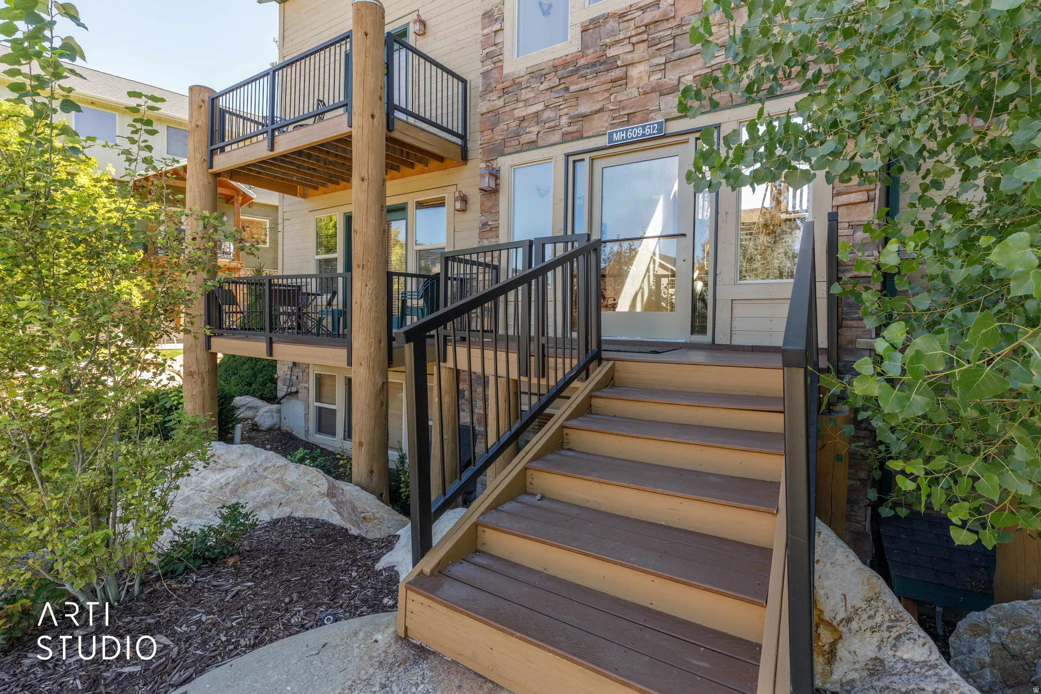 Unit 610 is the upper-left balcony. Multi-level exterior decks with black railings.