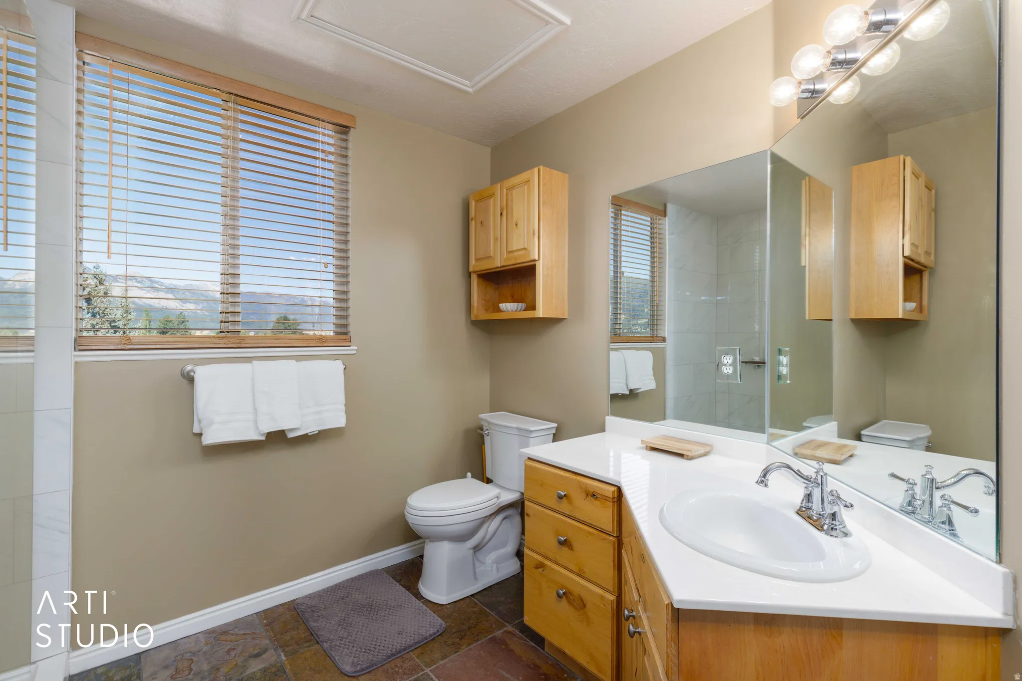 Wood-finish cabinetry and vanity with an integrated sink and chrome faucet