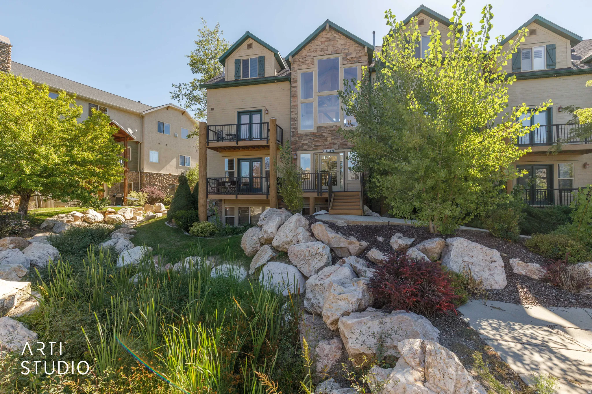 Multi-level property exterior with stacked stone and stucco siding