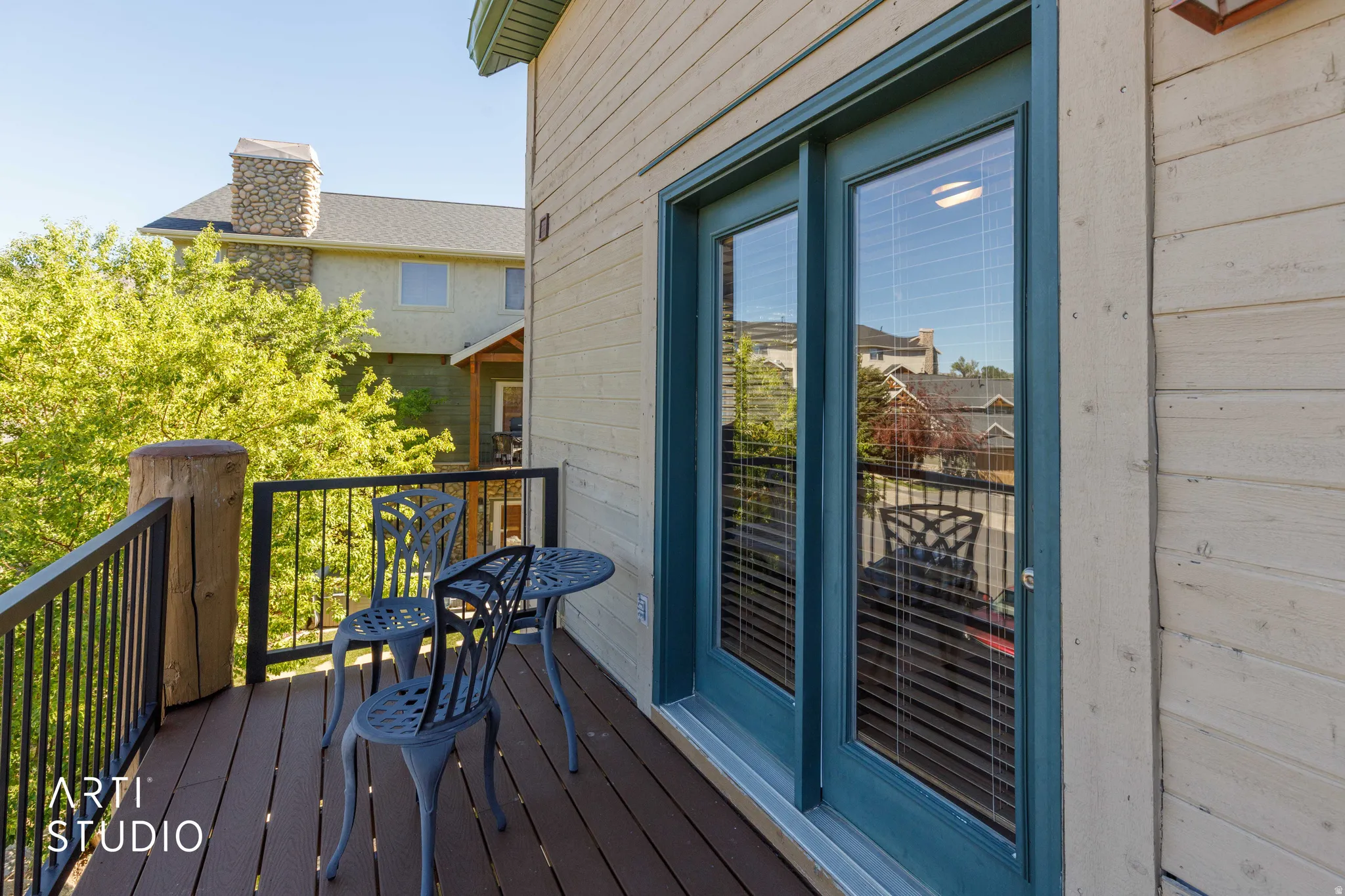 North balcony with wood-finish decking, black metal railings, and a natural wood post
