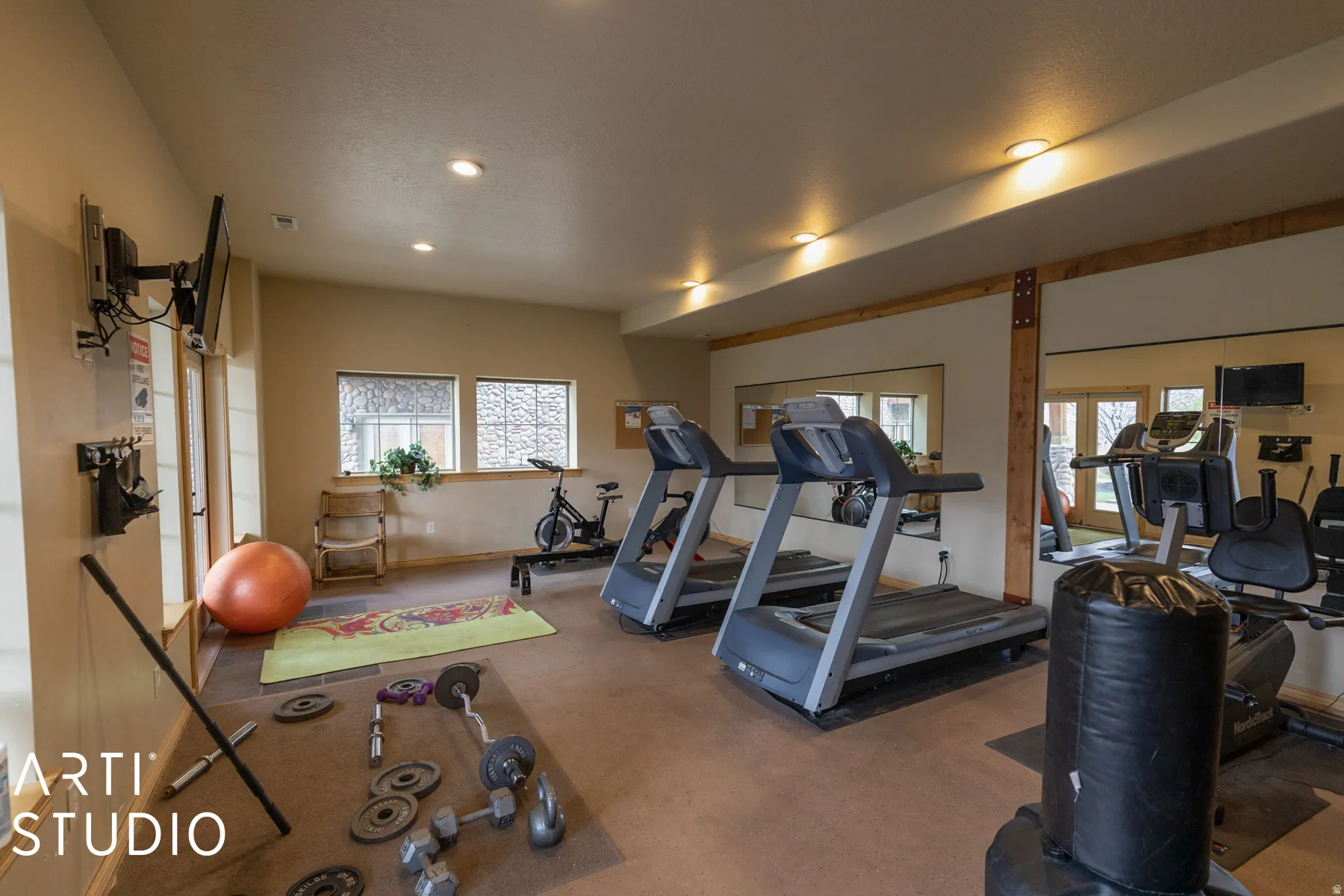 Dedicated fitness room featuring recessed lighting, a durable flooring surface, and multiple windows providing natural illumination
