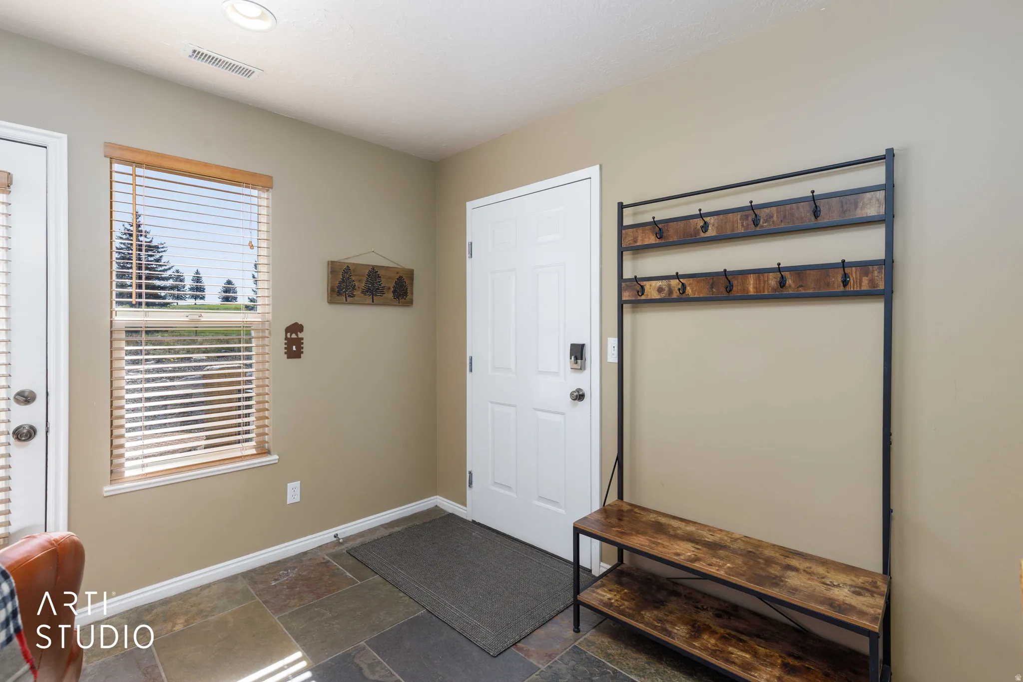 Stone tile flooring with a window offering exterior scenery