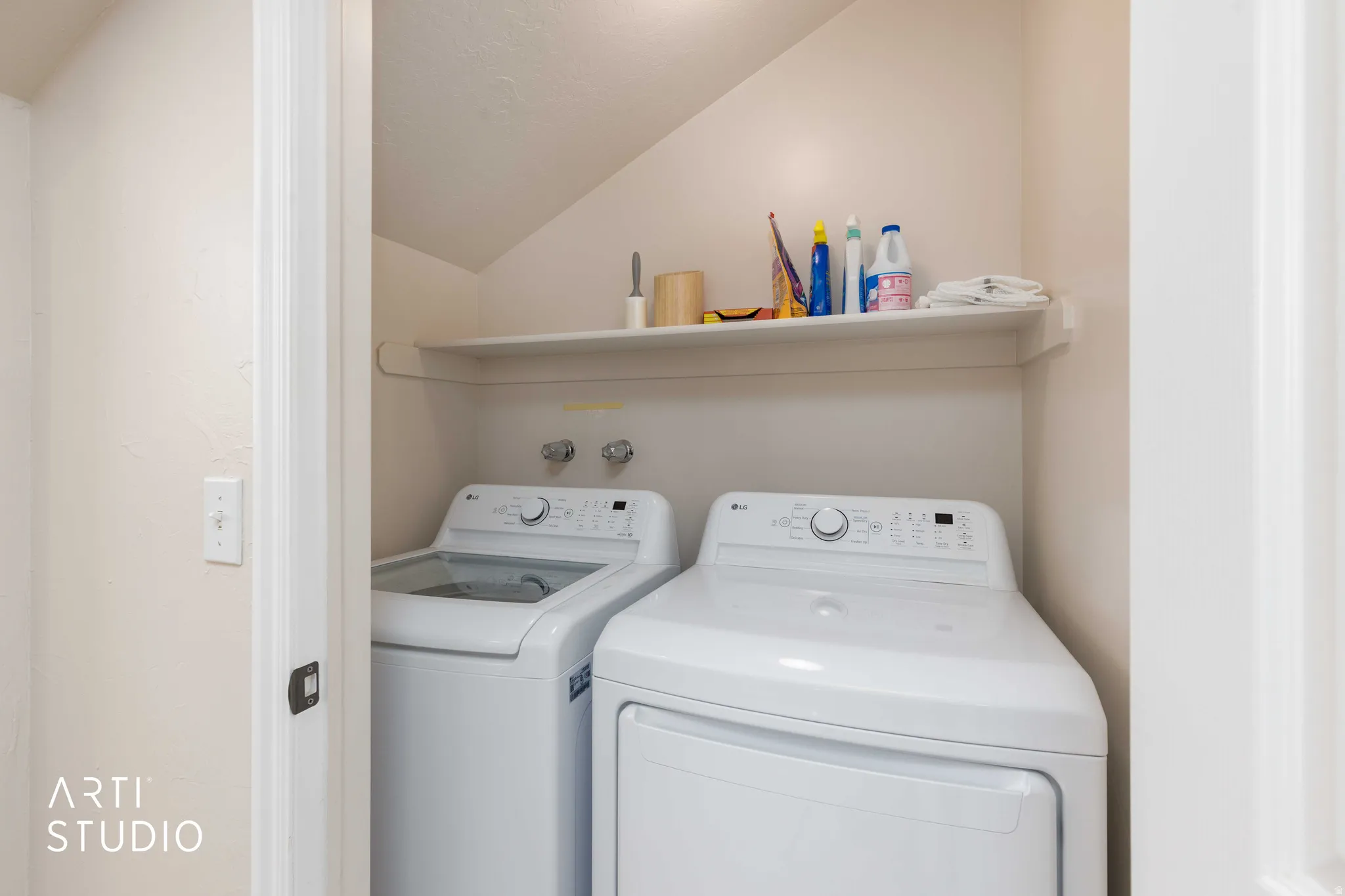 Dedicated laundry area inside the primary bedroom featuring a built-in shelf and connections for a washer and dryer