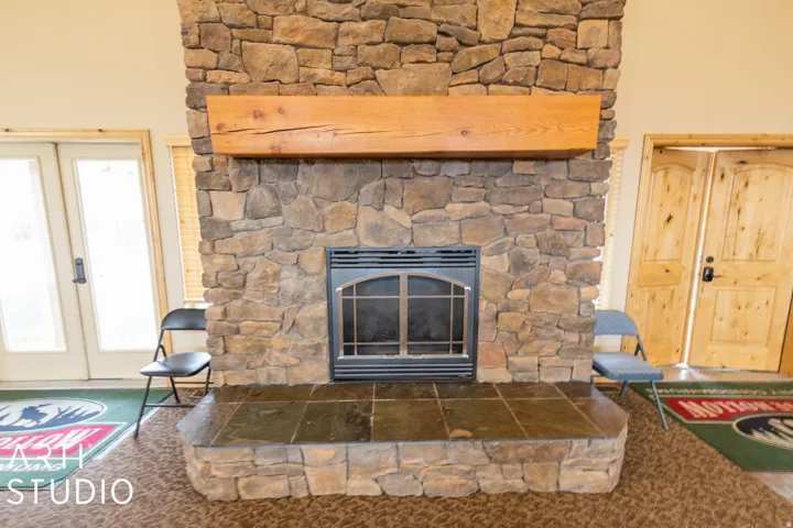Stone-clad fireplace with a wood mantel and tiled hearth