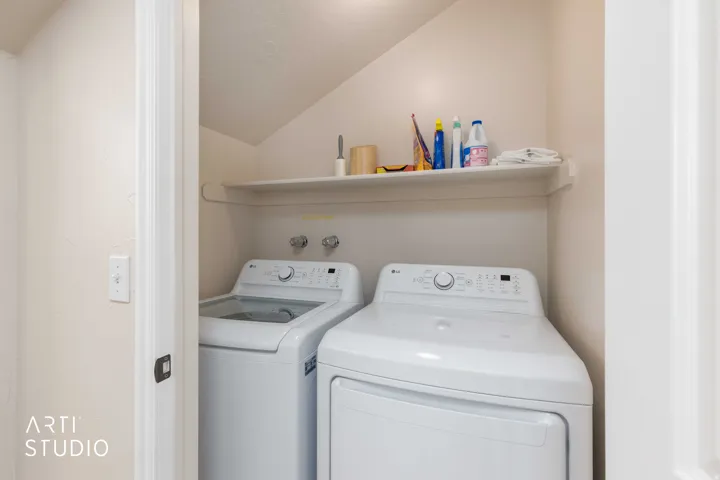 Dedicated laundry area inside the primary bedroom featuring a built-in shelf and connections for a washer and dryer