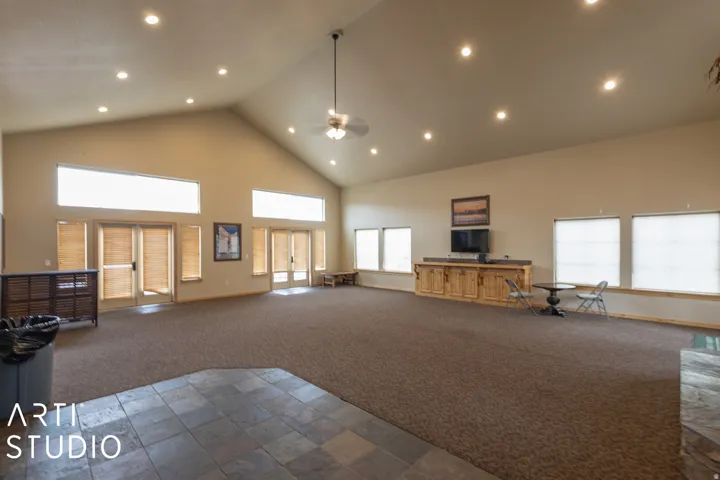 Vaulted ceiling with recessed lighting, ceiling fan, multiple windows with blinds, built-in cabinetry, and tile flooring