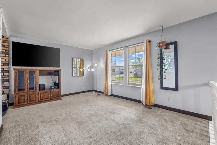 Expansive room with neutral carpeting and light gray walls