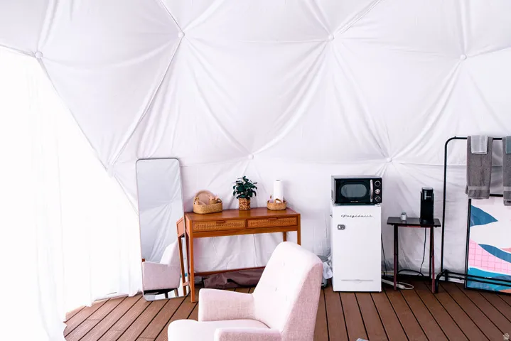 White fabric geodesic dome interior with wood-finish flooring