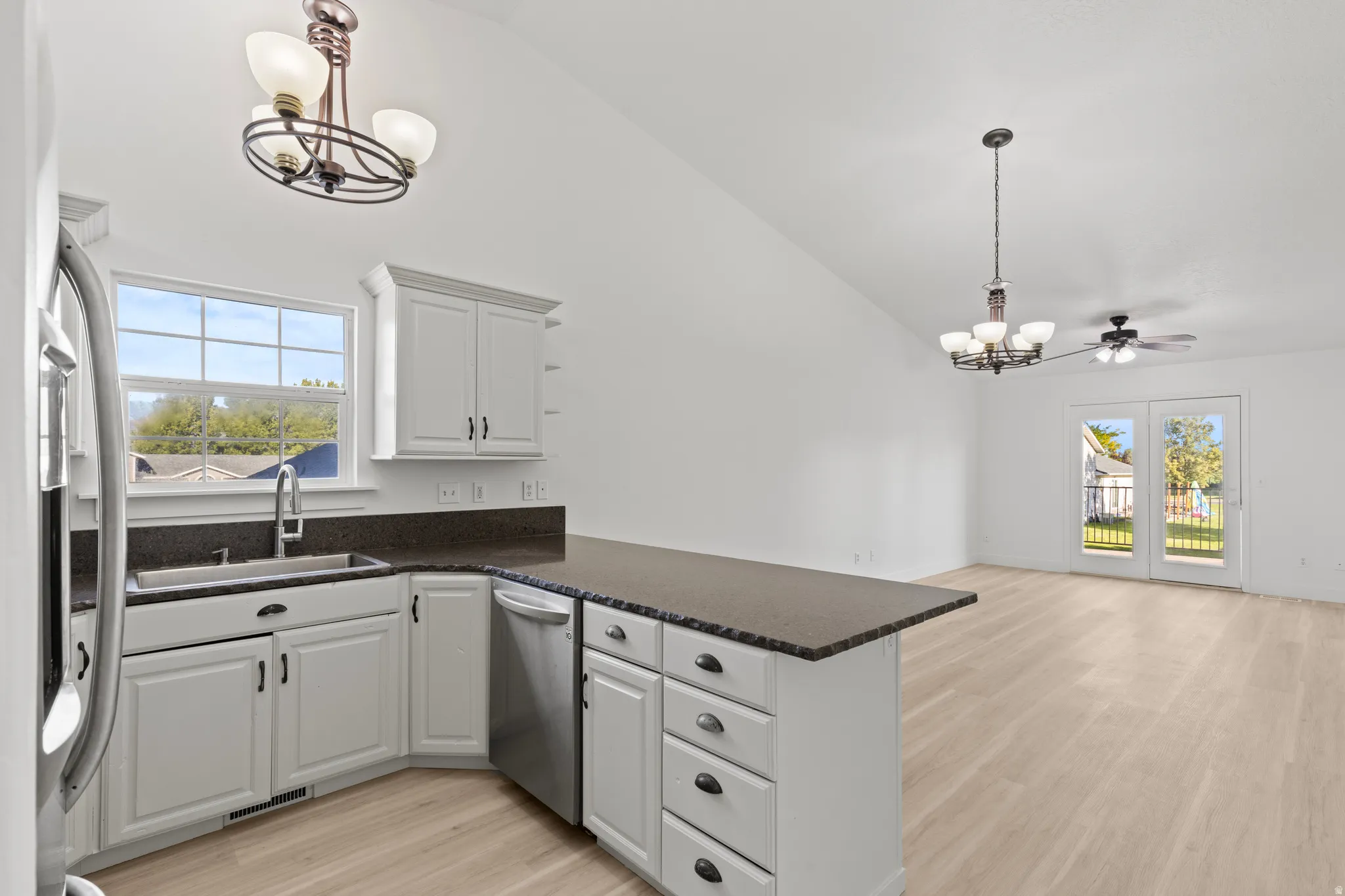 Kitchen featuring white cabinetry, dark countertops, and stainless steel appliances