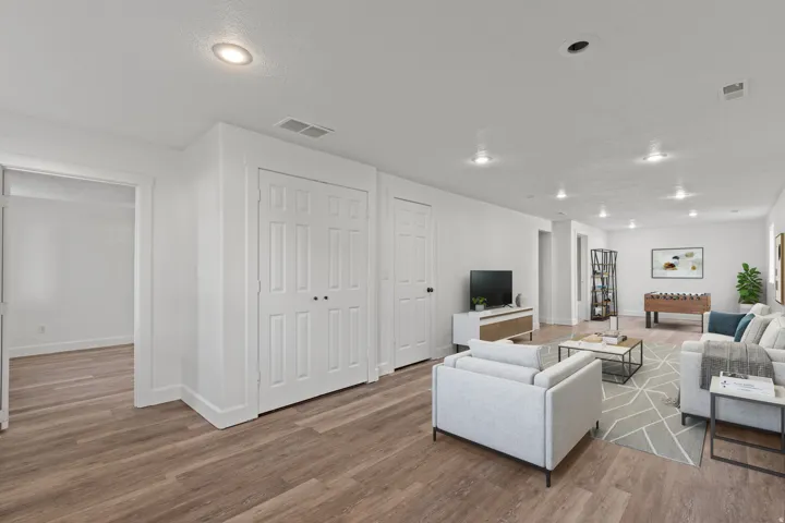Wood-finish flooring throughout, recessed lighting, and white paneled doors