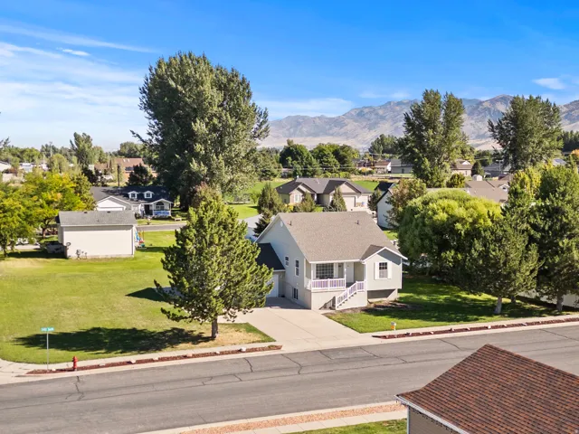 Single-family residence with a light gray exterior and white trim, featuring a concrete driveway and an attached garage