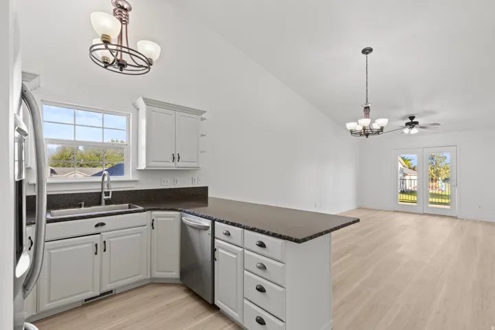 Kitchen featuring white cabinetry, dark countertops, and stainless steel appliances