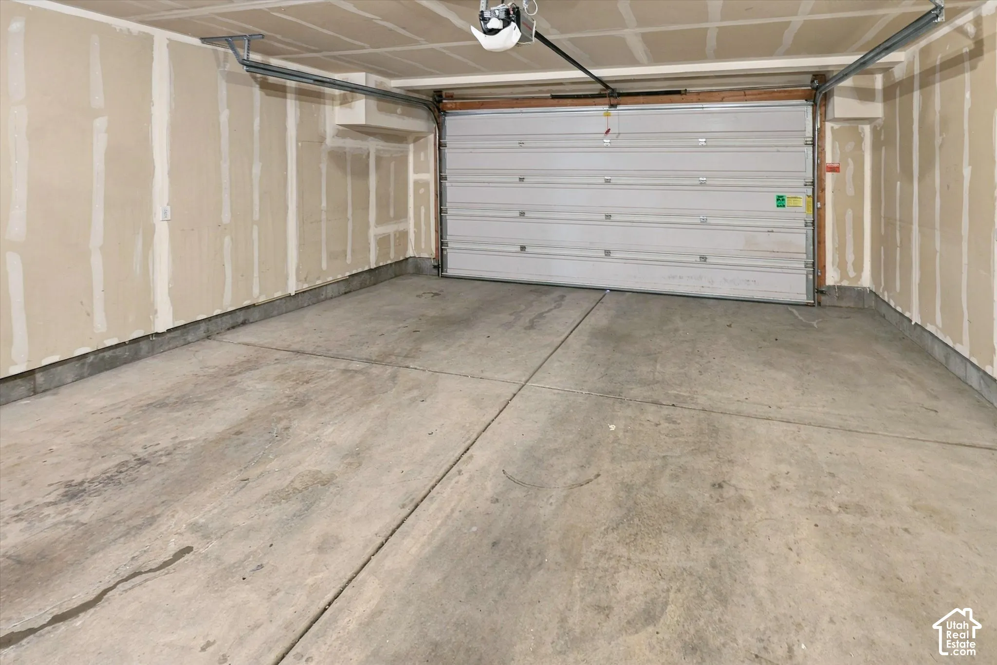 Two-car garage featuring a concrete floor, sectional overhead door, and automatic garage door opener