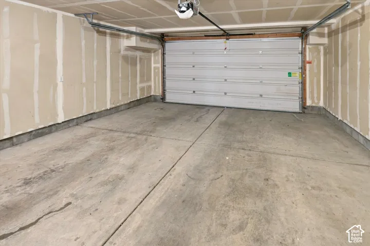 Two-car garage featuring a concrete floor, sectional overhead door, and automatic garage door opener