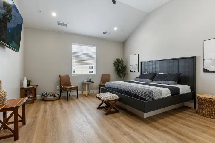 Vaulted ceiling with recessed lighting, wood-finish flooring, a window with blinds, and light-toned walls