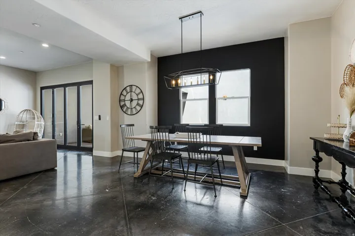 Polished concrete flooring, recessed lighting, and a linear chandelier illuminate this space