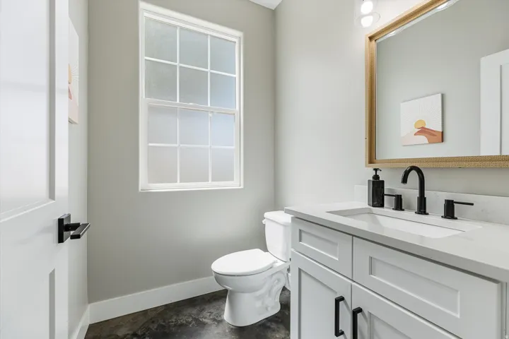 White shaker vanity with a composite countertop, undermount sink, and matte black fixtures