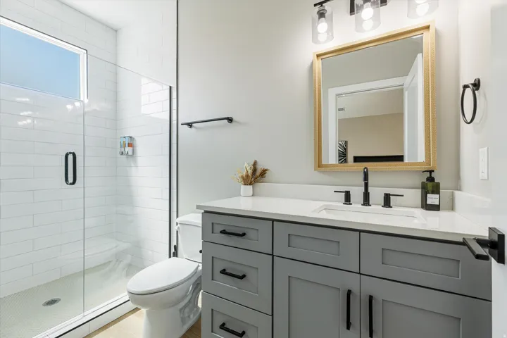 Glass-enclosed shower with white subway tile surround, a built-in bench, and an upper transom window