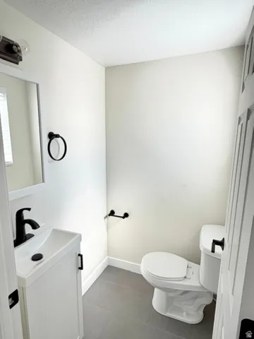 White vanity with integrated sink, matte black faucet, and cabinet hardware