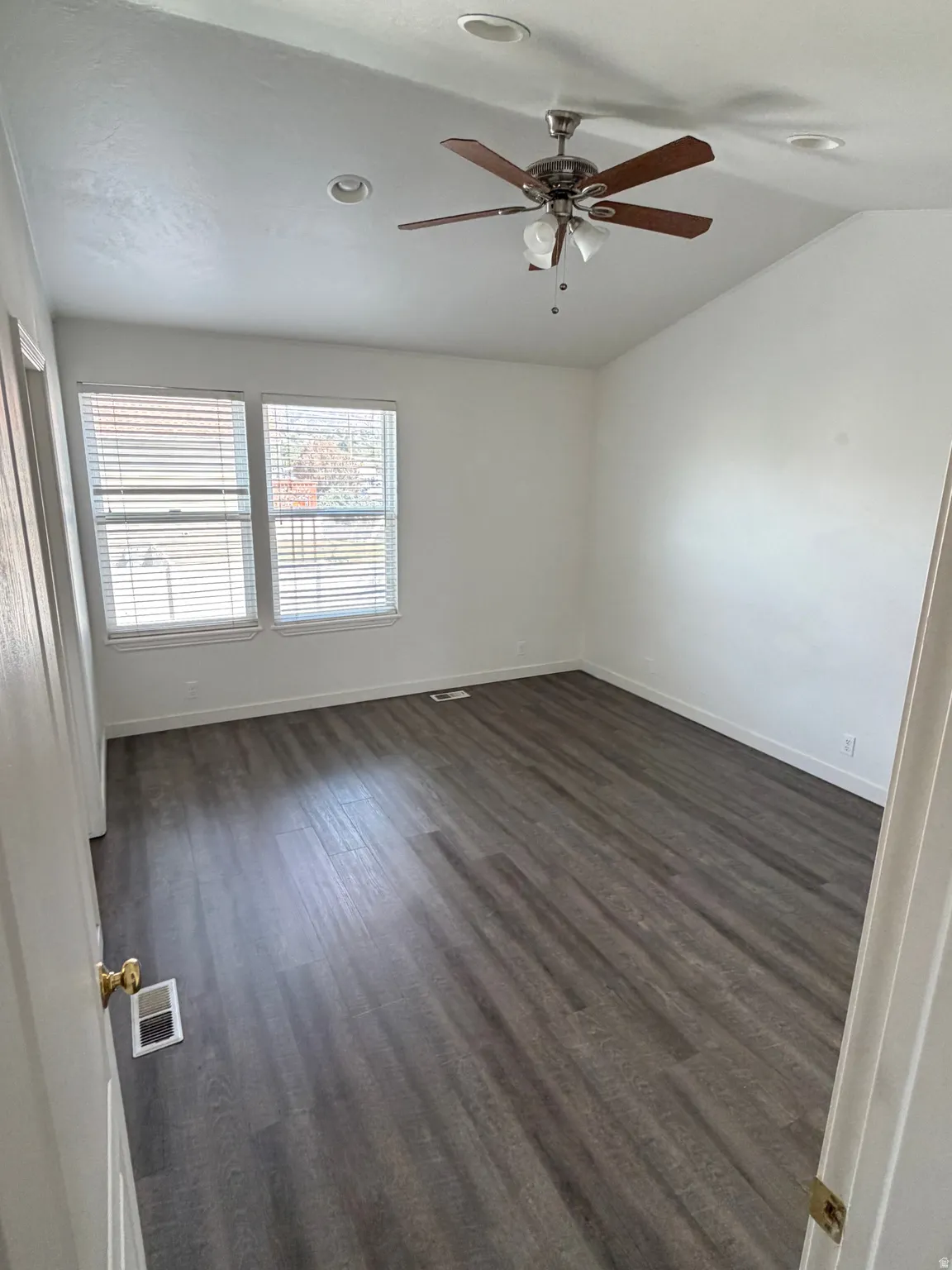 Vaulted ceiling, recessed lighting, wood-finish flooring, dual windows with blinds, and ceiling fan with integrated lighting