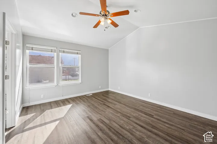 Vaulted ceiling with a ceiling fan, recessed lighting, wood-finish flooring, and white trim