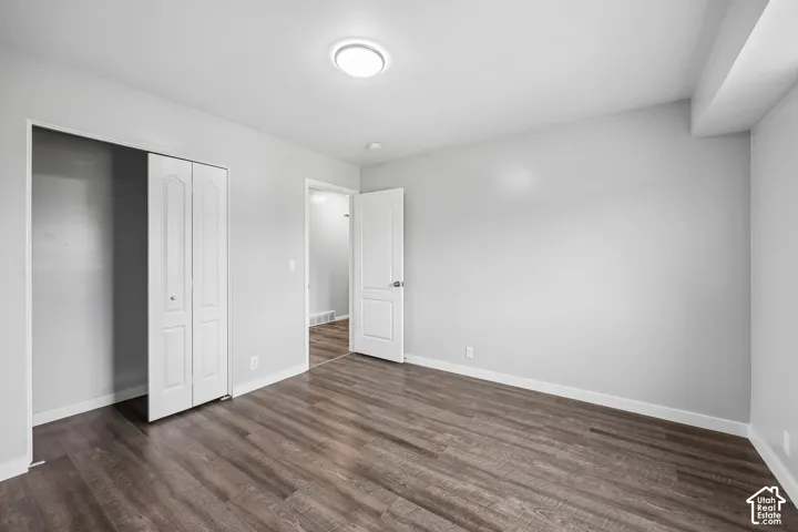 Wood-finish flooring, white walls, and a ceiling-mounted light fixture
