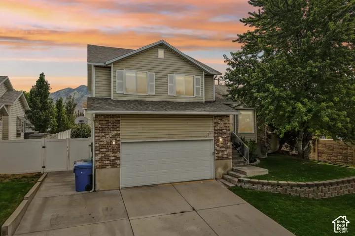 Two-story residence featuring a two-car garage, brick facade accents, and a concrete driveway