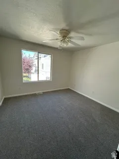Wall-to-wall carpeting with light-toned walls and a window