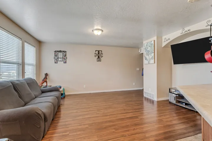Wood-finish flooring throughout, multiple windows with blinds, and recessed lighting fixtures