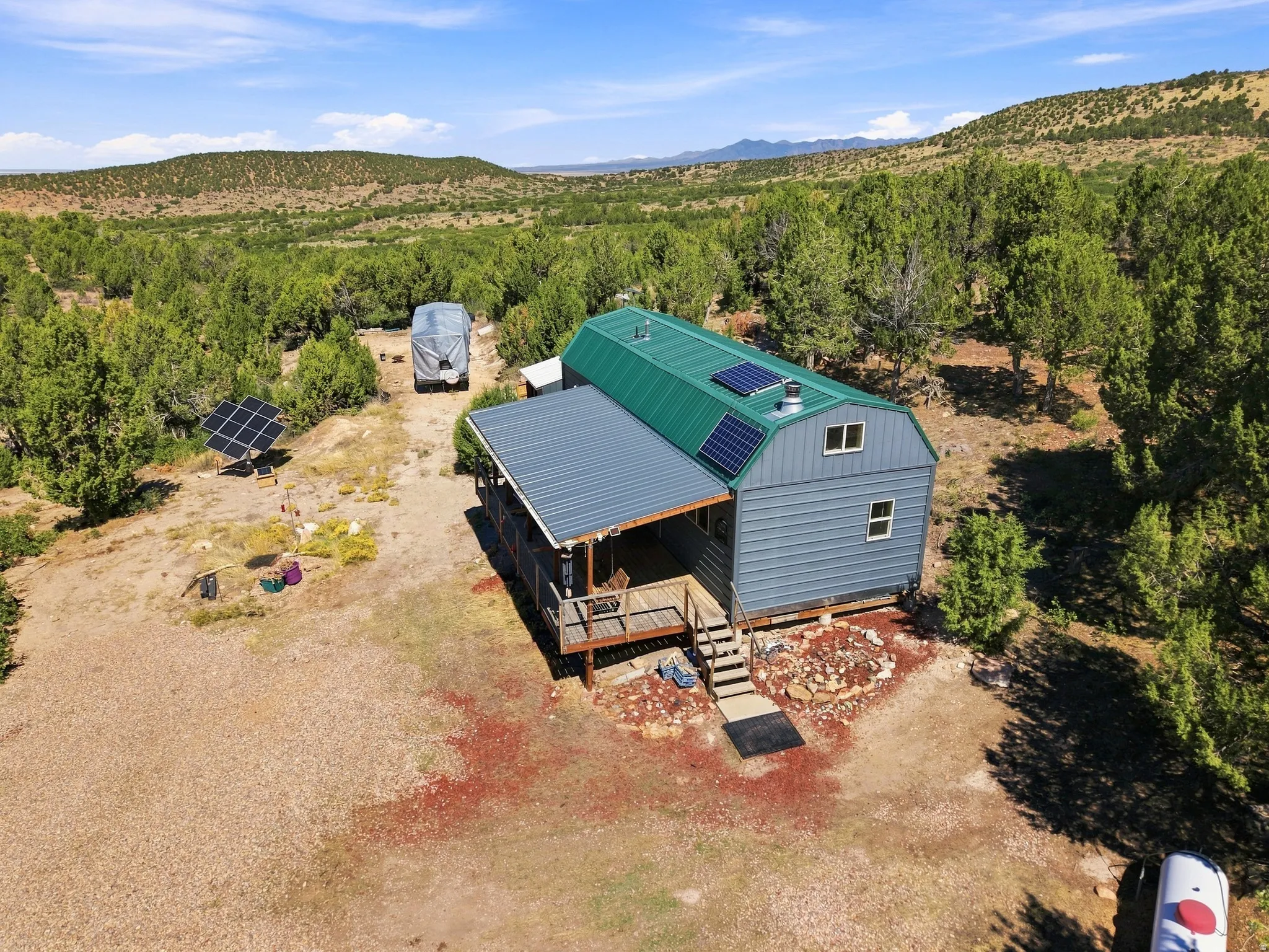 Barn-style structure with a green metal roof and solar panels