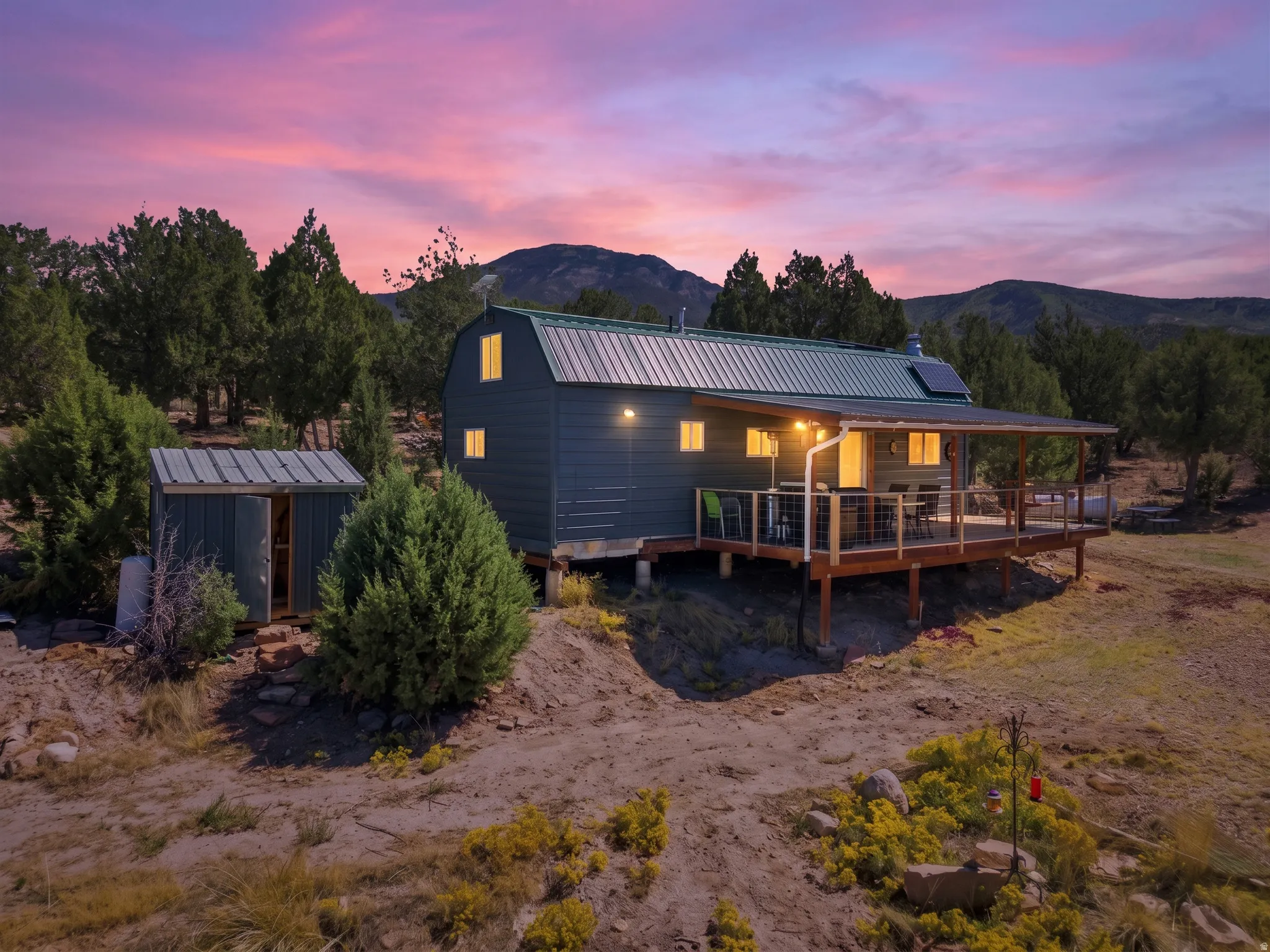 Detached residence featuring a covered deck, metal roof, and solar panels