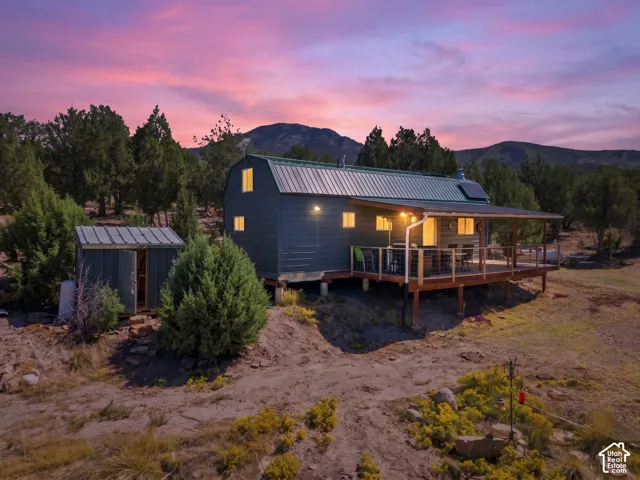 Detached residence featuring a covered deck, metal roof, and solar panels