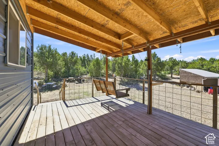 Covered wood-finish porch with a suspended bench swing