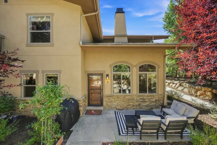 Exterior patio with a concrete surface, stucco siding, and stone veneer accents