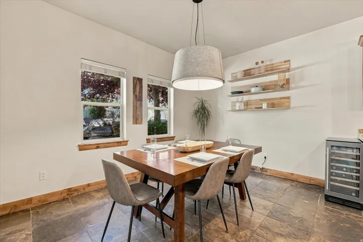 Recessed windows with wood sills, wood-finish flooring, built-in floating wood shelves, and a built-in beverage refrigerator